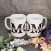 11 oz white porcelain coffee mug. Personalized with the word "mom" in large black font. In the center of the word "mom" are children's names in a black cursive font.
