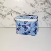 Small blue butterfly pattern accessory bag with front window pocket for makeup remover wipes. Fully lined interior. Zip closure with attached keyring. Measures 6 inches wide. Window pocket allows easy access to a packet of wipes (not included).