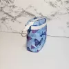 Small blue butterfly pattern accessory bag with front window pocket for makeup remover wipes. Fully lined interior. Zip closure with attached keyring. Measures 6 inches wide. Window pocket allows easy access to a packet of wipes (not included).