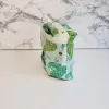 Small green dragonfly pattern accessory bag with front window pocket for makeup remover wipes. Fully lined interior. Zip closure with attached keyring. Measures 6 inches wide. Window pocket allows easy access to a packet of wipes (not included).