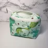 Small green dragonfly pattern accessory bag with front window pocket for makeup remover wipes. Fully lined interior. Zip closure with attached keyring. Measures 6 inches wide. Window pocket allows easy access to a packet of wipes (not included).