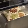 Autumn Leaves Eco-Friendly Dish Scrubber, 5x4 inches, featuring a vibrant autumn leaves design, dual-sided for versatile cleaning, and padded for comfort and durability.