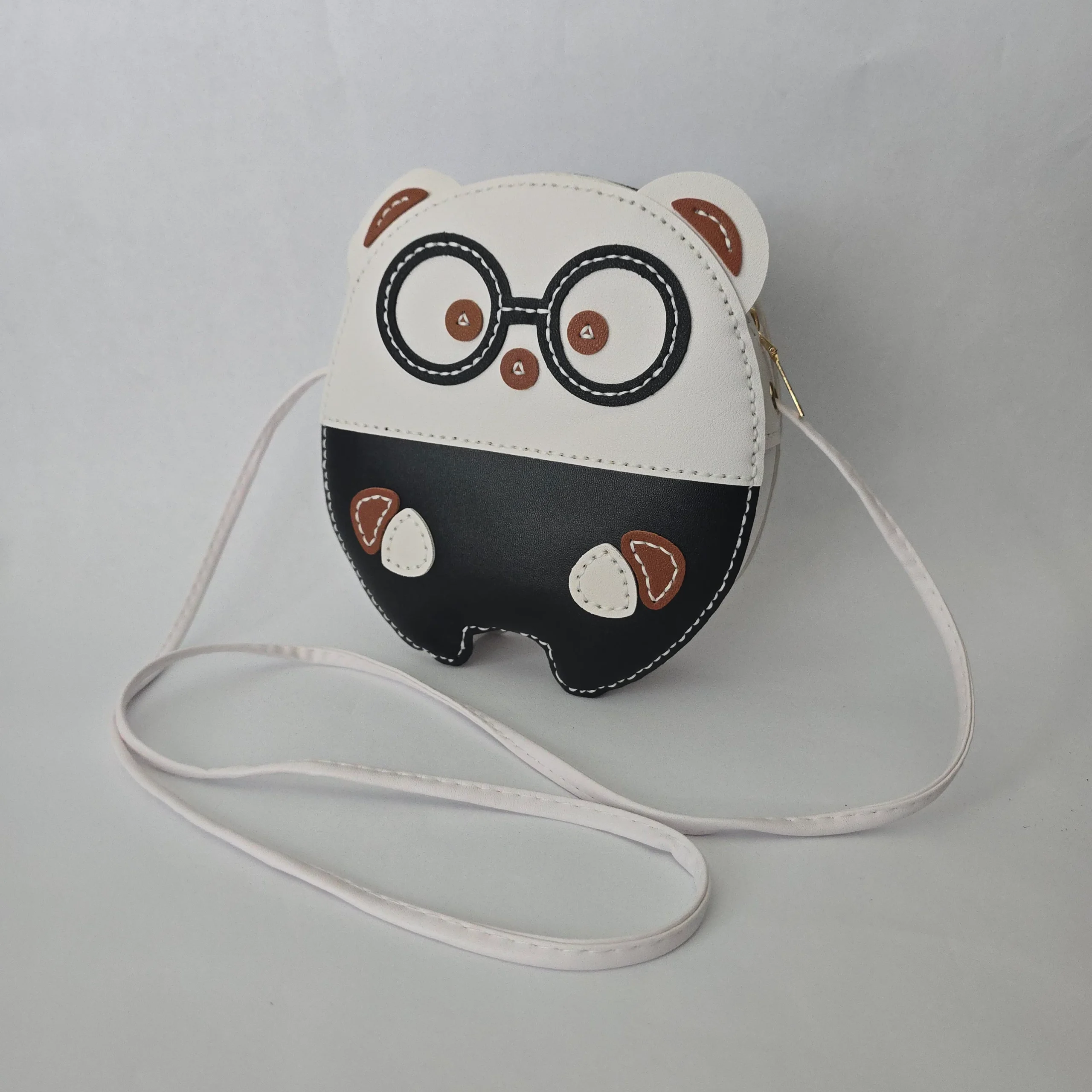Handmade black and white character bag in vegan leather, featuring glasses, 8 inches tall, 7 inches wide, with zip closure and crossbody strap.
