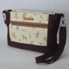 Handmade floral purse in cream and pink with espresso trim, adjustable strap, dual exterior zip pockets, and zipper closure.