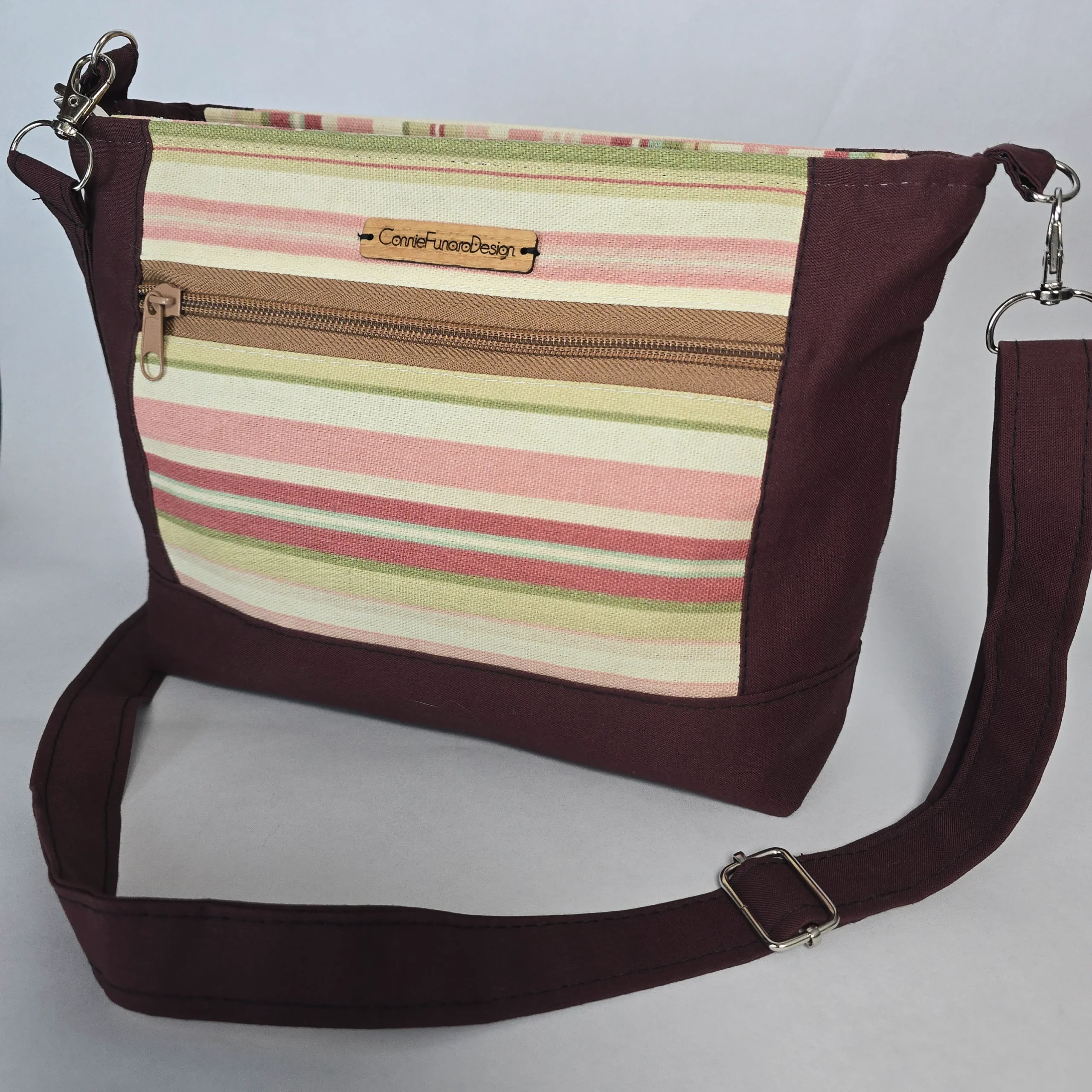 Handmade striped purse with pastel pinks and neutral tones, espresso trim, adjustable strap, dual exterior zip pockets, and main zipper closure.