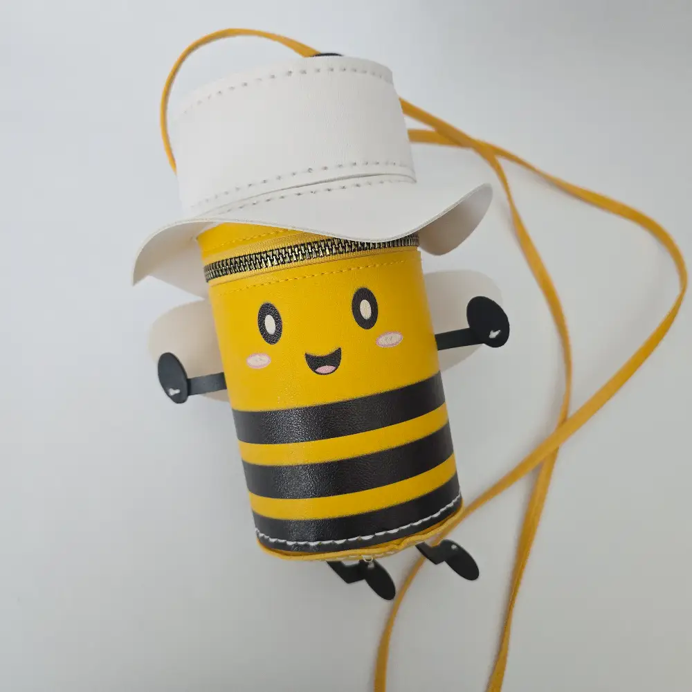 Handmade bumble bee character purse in vegan leather with white wings, matching hat, cute face, crossbody strap, and secure zip closure.