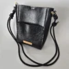 Handmade black bucket bag with vegan leather, gold-tone hardware, magnetic closure, front pocket, and adjustable strap. Compact and versatile for everyday use.
