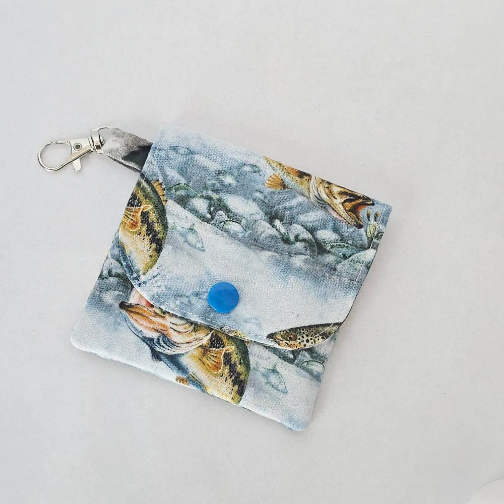 Handmade fishing wallet for cards and paper cash, featuring three pockets, a snap closure, and a lobster claw clasp, made from 100% cotton fabric.