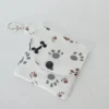 Handmade dog paw print wallet with three pockets, a snap closure, and a lobster claw clasp, made from 100% cotton fabric featuring gray and brown paw prints and black dog bones.