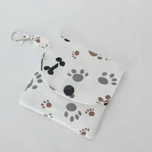 Handmade dog paw print wallet with three pockets, a snap closure, and a lobster claw clasp, made from 100% cotton fabric featuring gray and brown paw prints and black dog bones.
